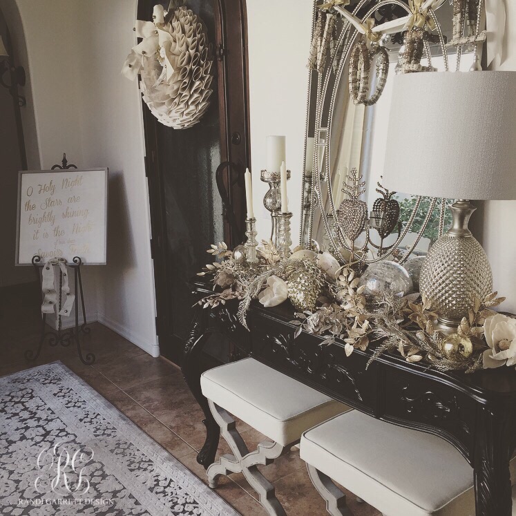Silver and gold entry table with Wisteria stools and mercury glass candles sticks and ornaments