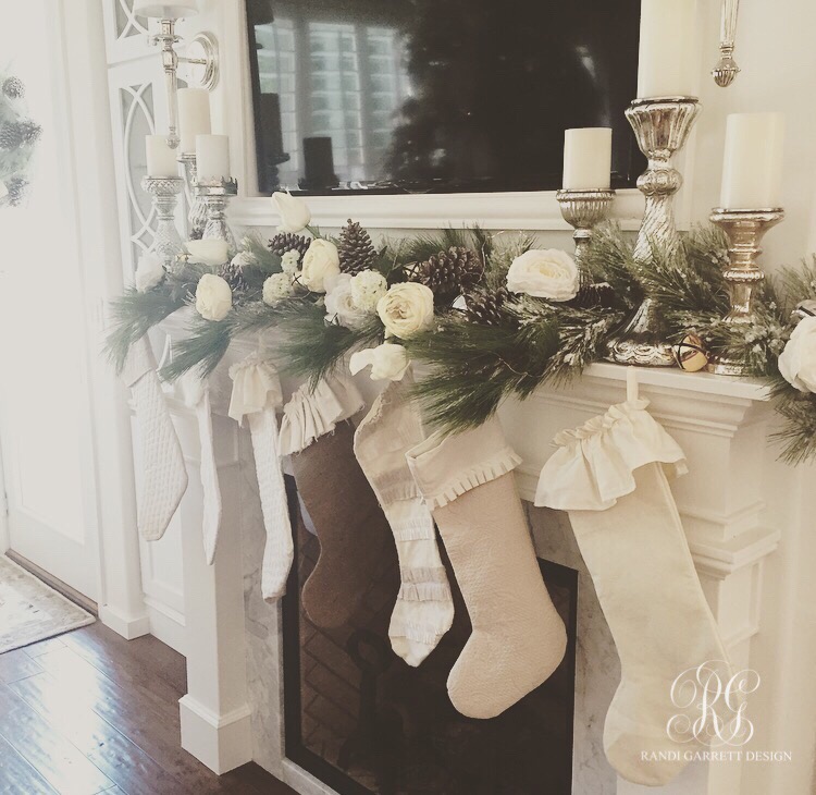 Ruffled stockings hung on a pine and floral mantel with mercury glass candlesticks