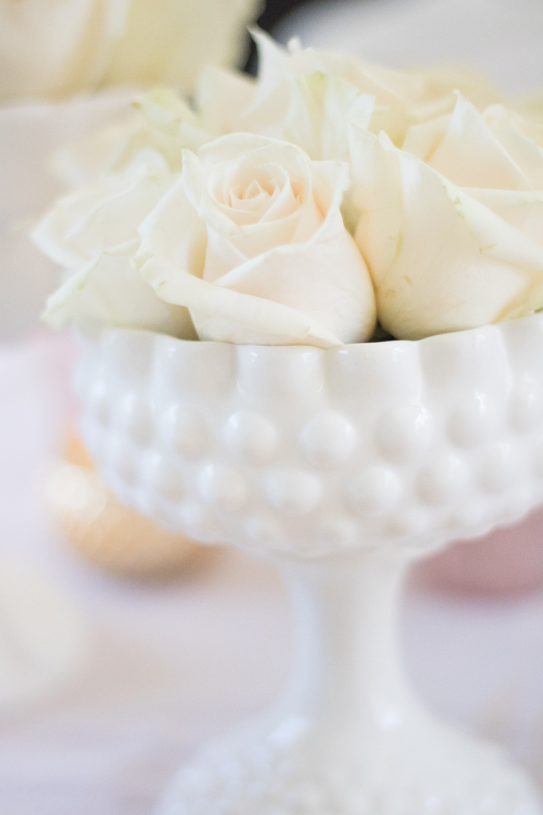 White rose arrangment in milk glass vase