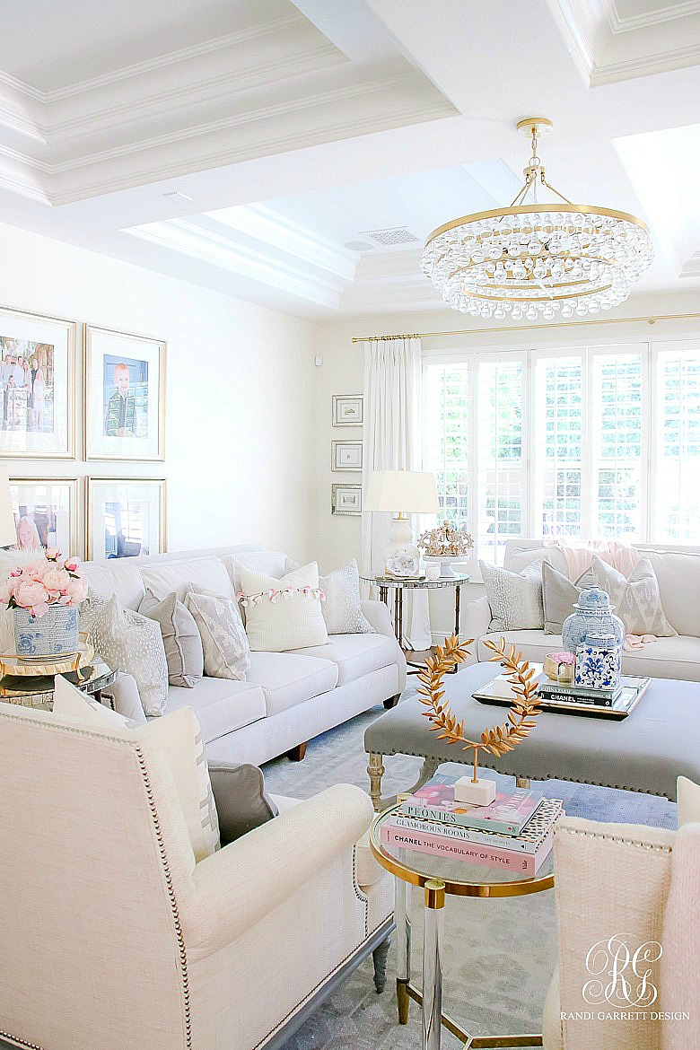Neutral living room styled for summer - tassel pillows - pink + blue accessories