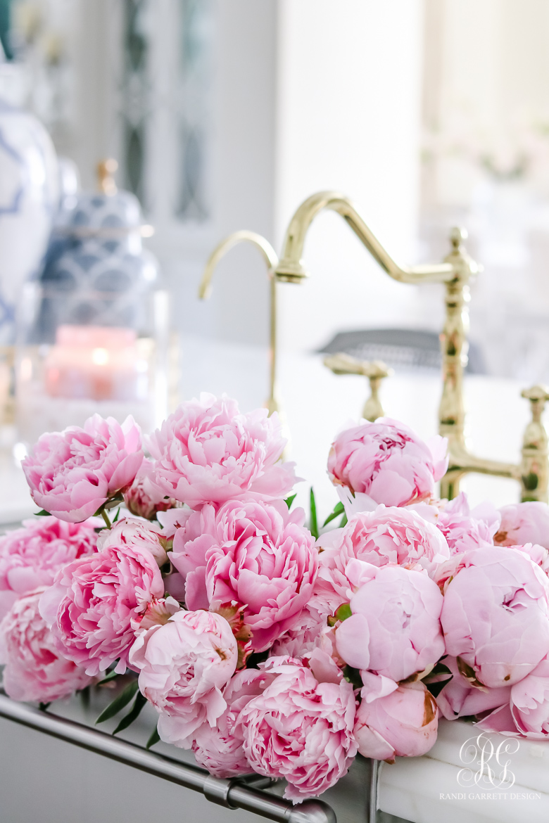 pink peonies in stainless steel sink brass faucet