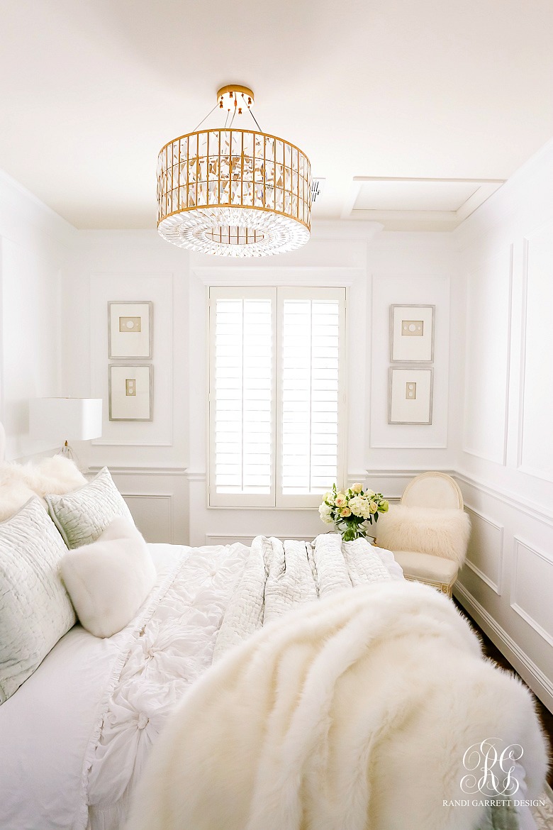 glam guest bedroom - white walls - wainscoting - glam gold crystal chandelier