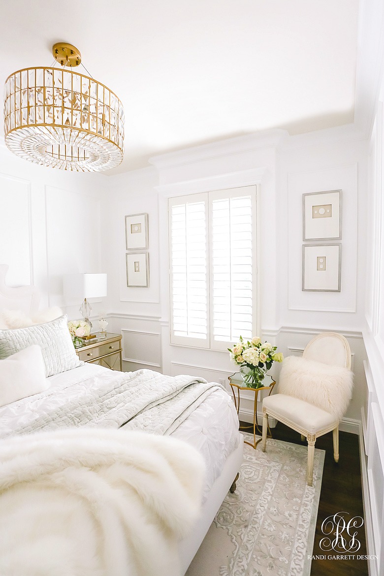 glam bedroom with white walls and wainscoting and lux bedding