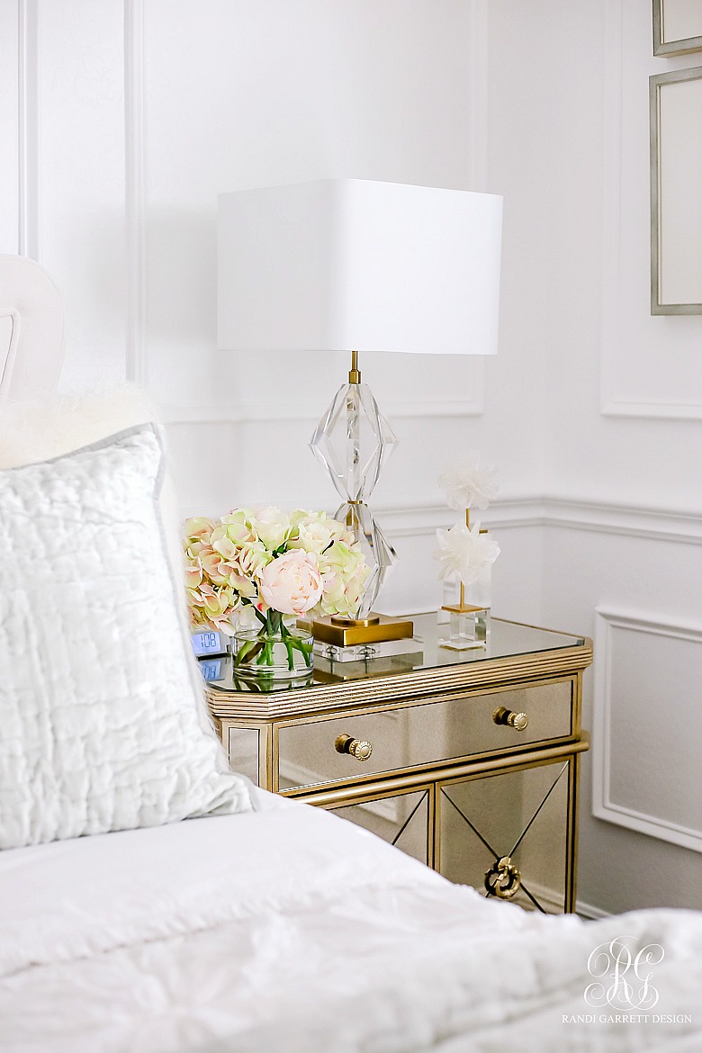 Glam guest bedroom with mirrored nightstand and velvet bed