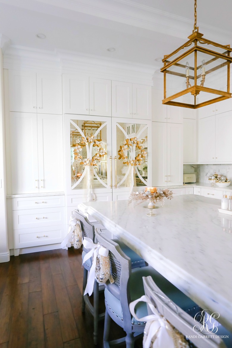 White and gold kitchen with wreaths on fridge doors