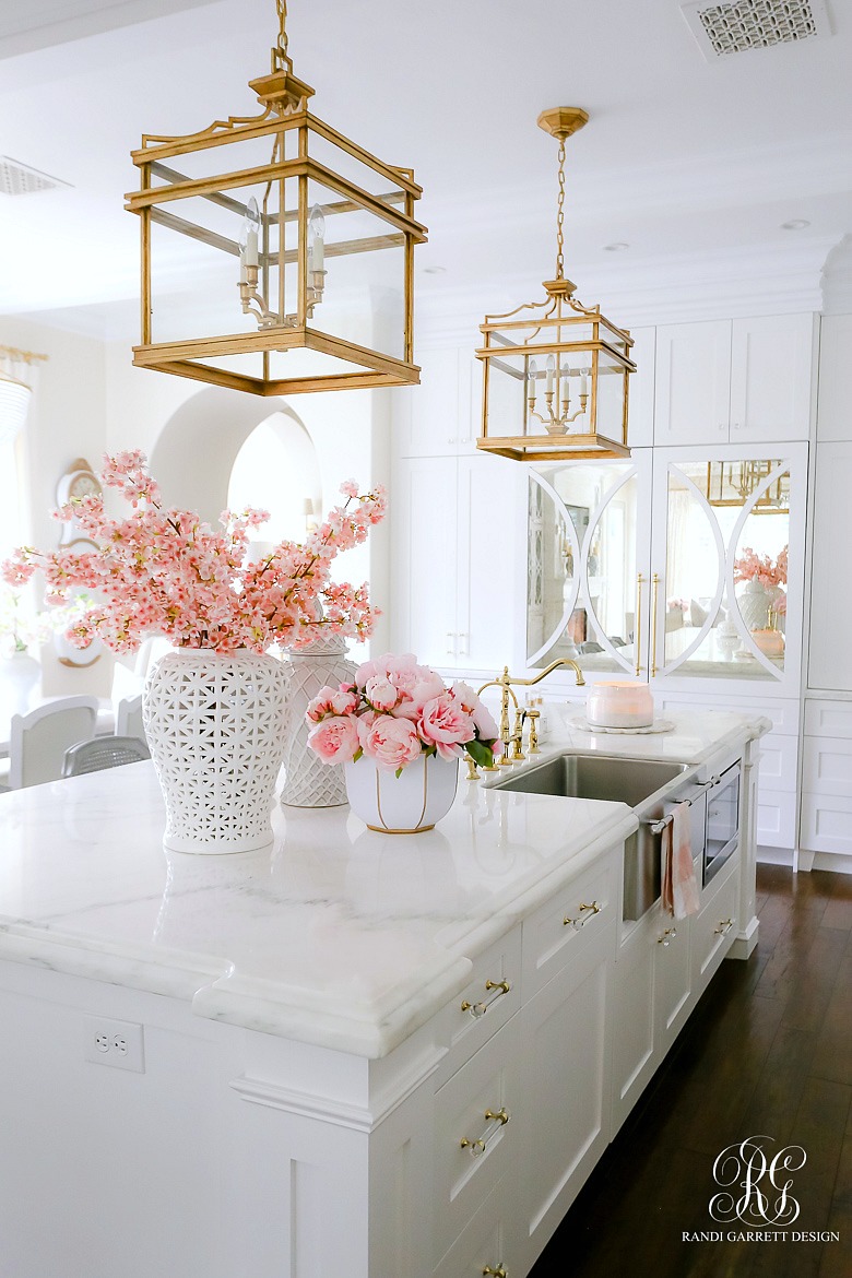 glam white kitchen - gold lanterns - white ginger jars with pink flowers