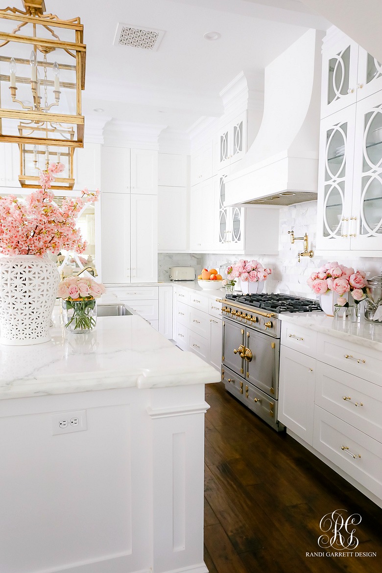 elegant white kitchen - la conrue range - marble counter tops - brass lanterns